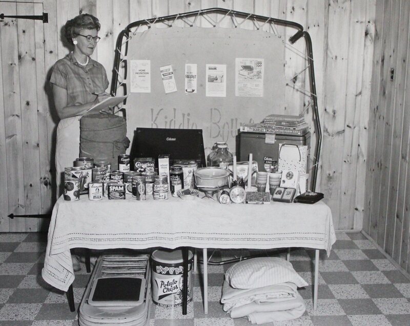 1950s his photograph depicts a woman as she takes an inventory of supplies for her household's fallout shelter.