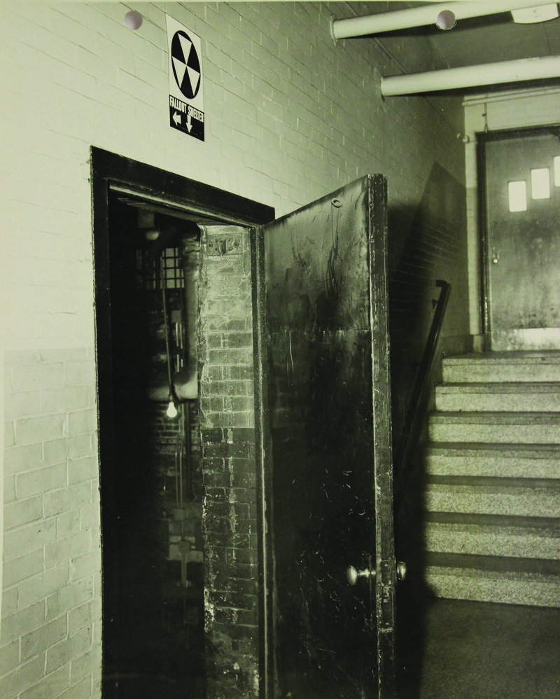 1962. fallout shelter sign in a doorway at Columbus High School in Boston, Massachusetts.