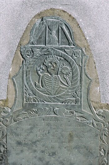 The flamboyant Tombstone of Susanna Jayne in the Old Burial Hill in Marblehead, Massachusetts, and its hourglass flanked with human bones. 