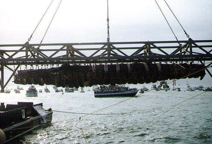 The wreck oof <em>H.L. Hunley</em>, suspended from a crane during its recovery from Charleston Harbor, August 8, 2000. 