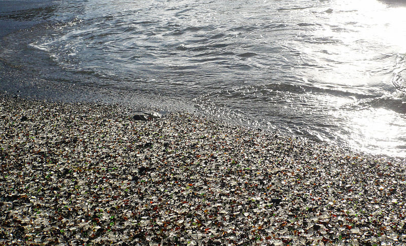 The waves wash over the mix of rocks and ground-down glass pieces on the site of a former trash dump, now Glass Beach in Fort Bragg, California