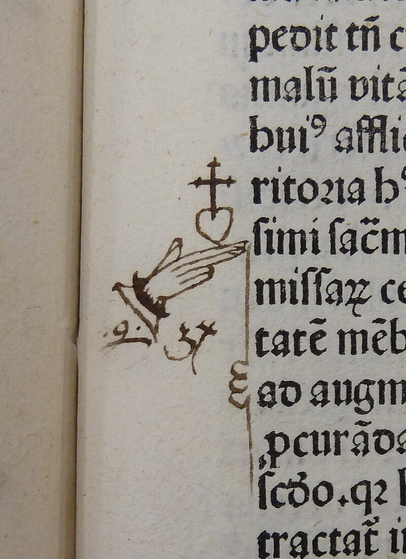 A manicule extending both index and middle finger toward the text.