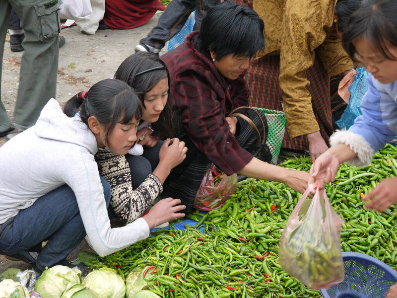 Selecting green chillies at Paro Market, Bhutan. 