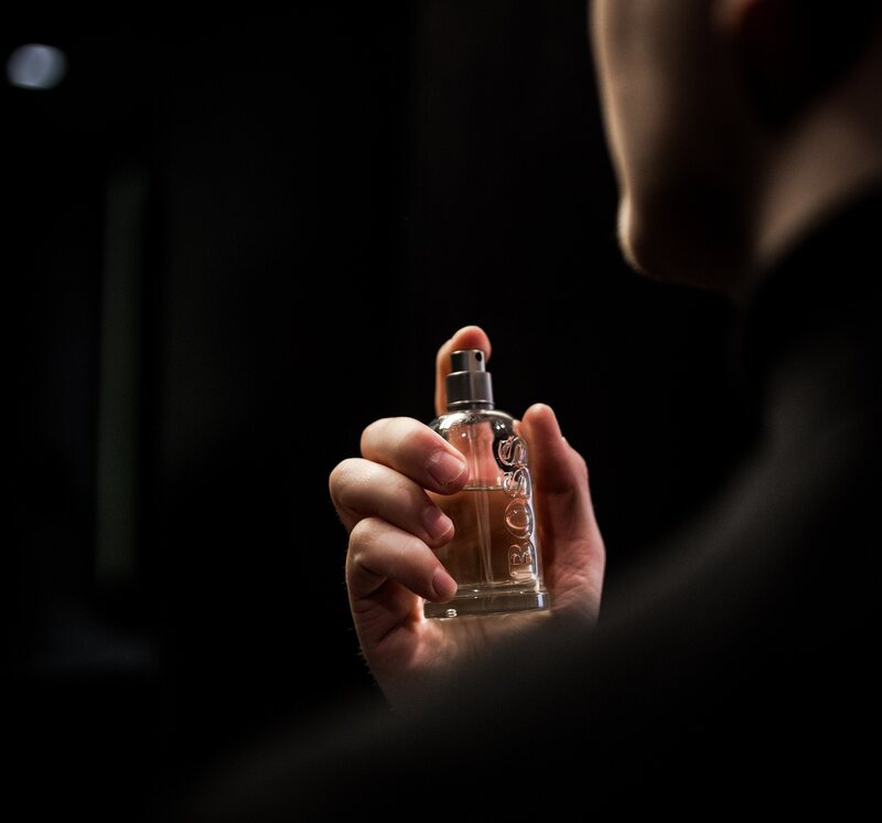 A man putting on a perfume. 