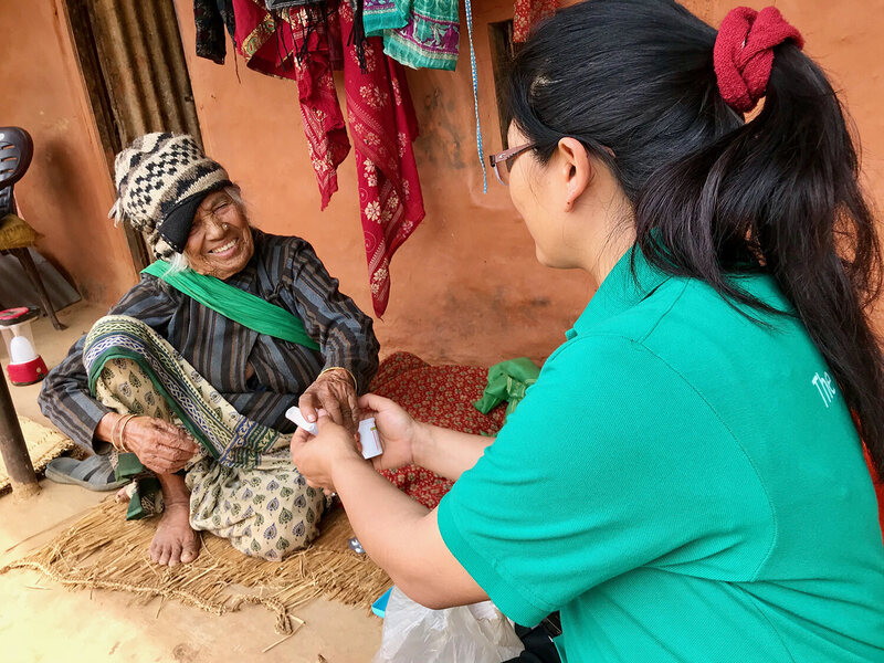 Dr. Tamang consults Kumari on proper use of her inhaler.