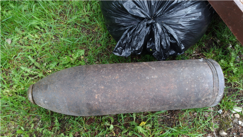 The 100-year-old artillery shell beside more conventional trash.