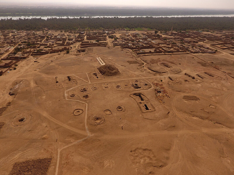 The ancient royal cemetery of El-Kurru, with the modern            town of El-Kurru and the Nile in the background.