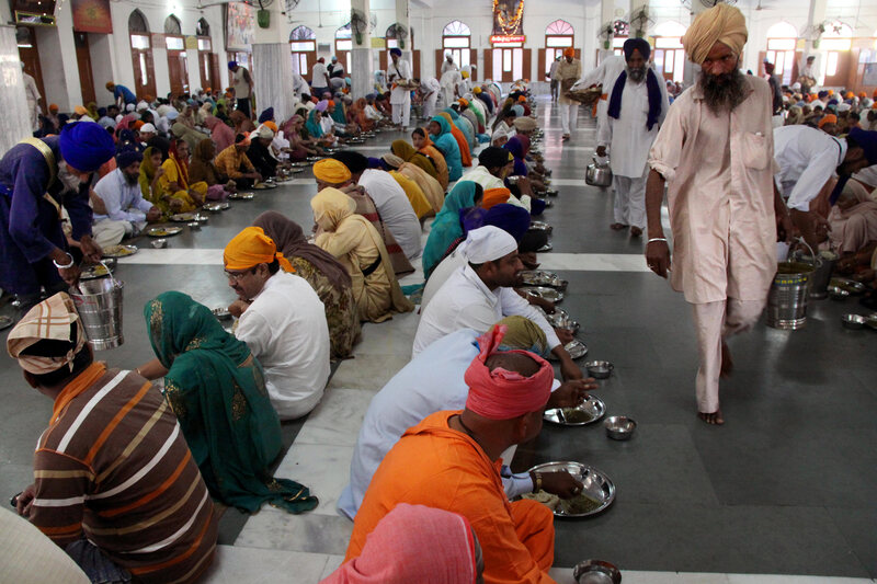 People sit modestly on the floor when eating langar at the Golden Temple.