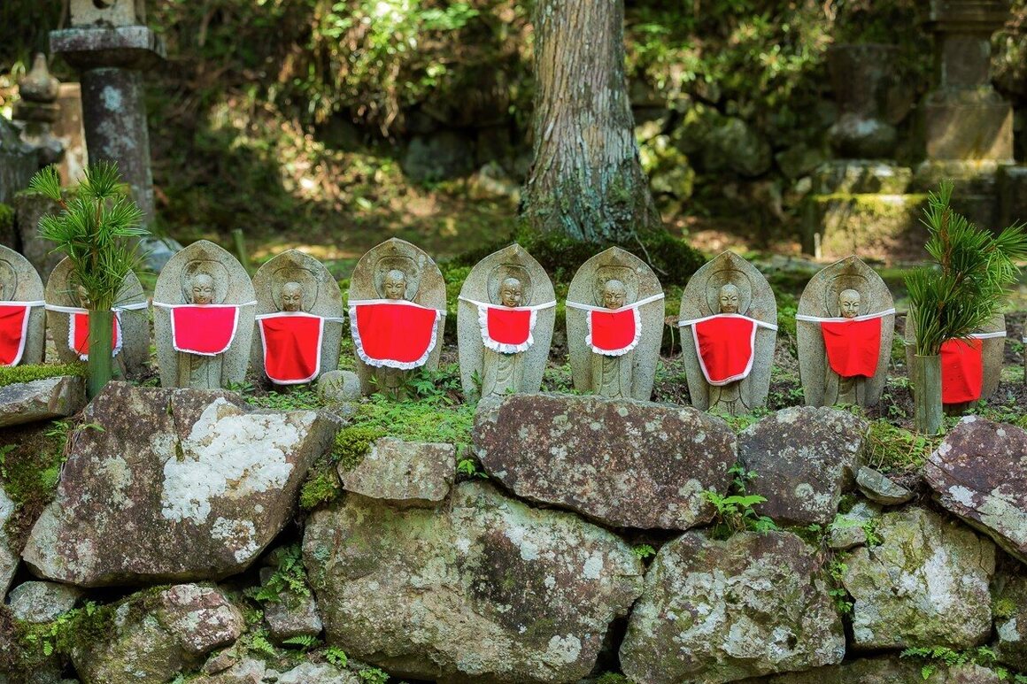 A common sight in cemeteries throughout Japan, a string of red-bibbed Jizos.