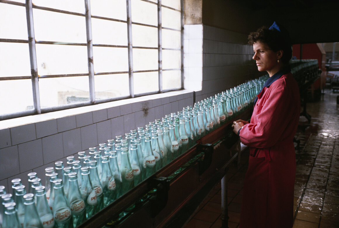 A woman inspects Pepsi bottles at a plant near Bucharest, on November 24, 1989.