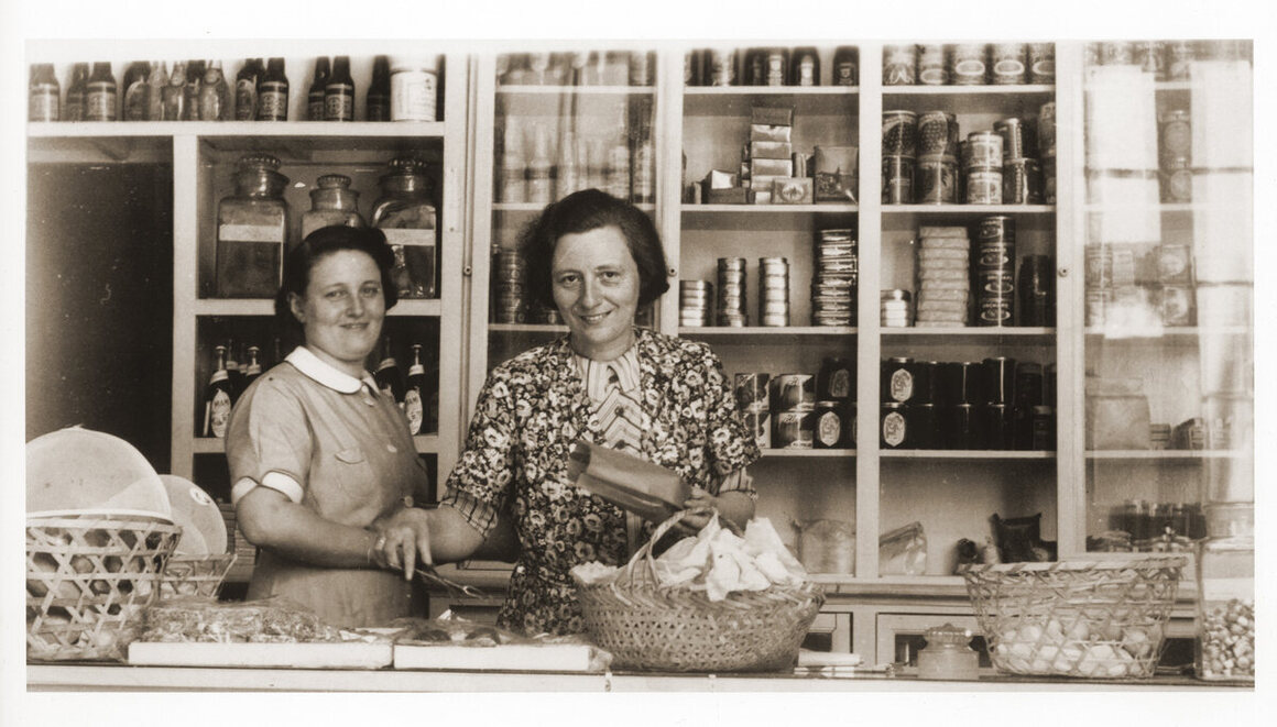 Two German Jewish refugee women stand behind the counter of the Elite Provision Store (delicatessen) in Shanghai.