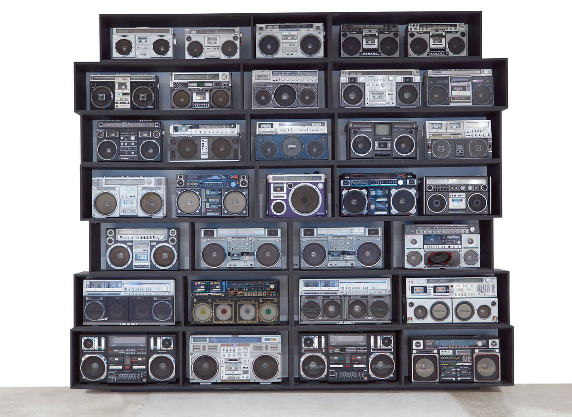 DJ Ross One's <em>The Wall of Boom</em> includes a pair of Clairtone Super Jumbos (first and third on the bottom row), made famous by Radio Raheem in Spike Lee's <i>Do the Right Thing</I>, in addition to other coveted vintage boomboxes. 