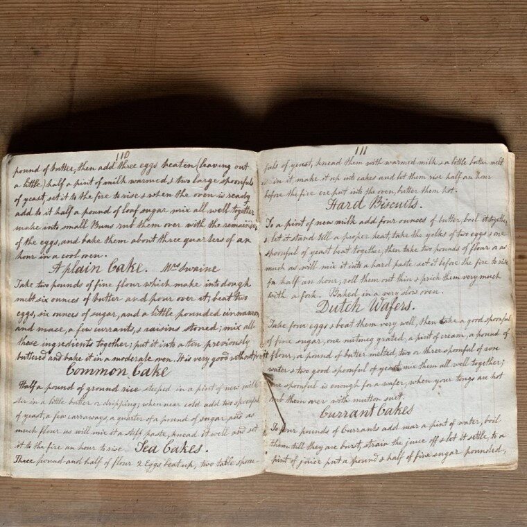 The 1830s manuscript cookbook, open to recipes for plumb bake, hard biscuits, currant cake, and more.