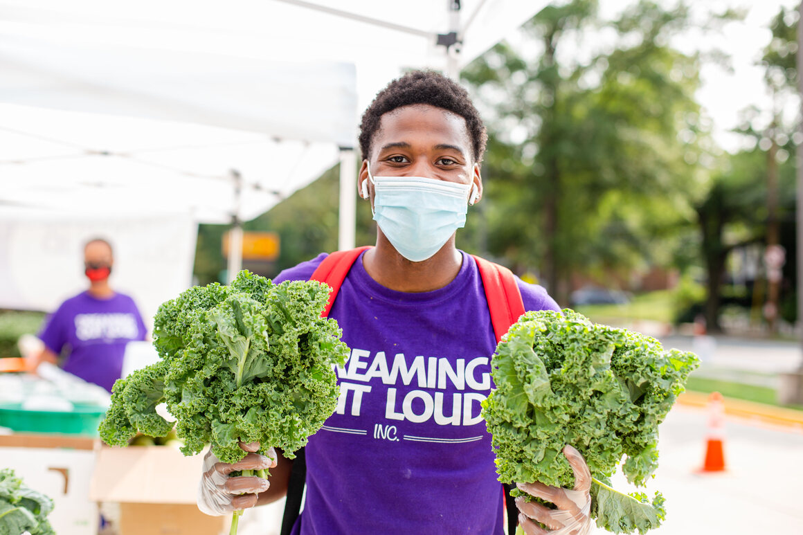 Dreaming Out Loud Food Hub Assistant Justin at the market at Kelly Miller Middle School.