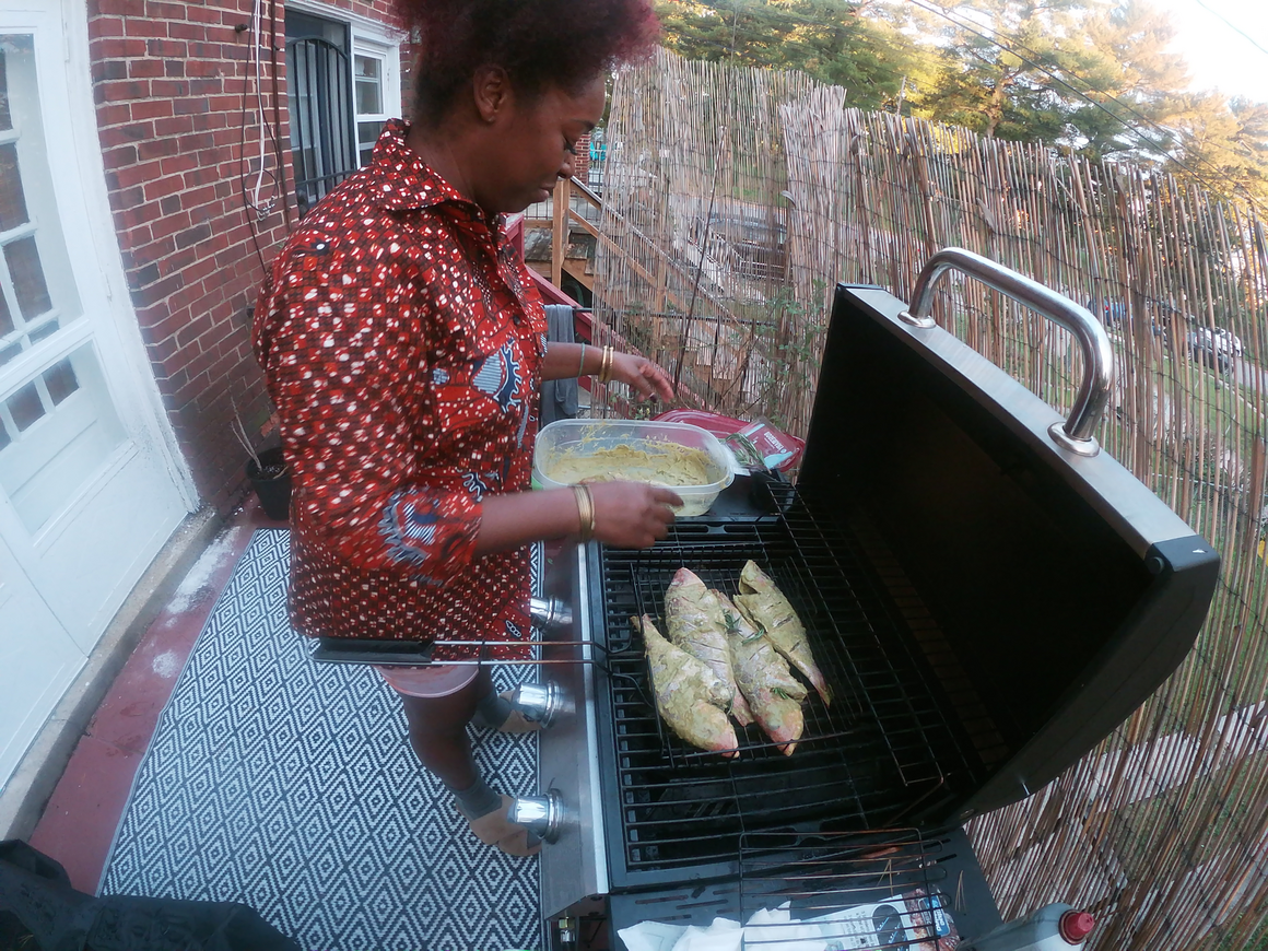 Sharayna Ashanti Christmas grills fish at her home. 