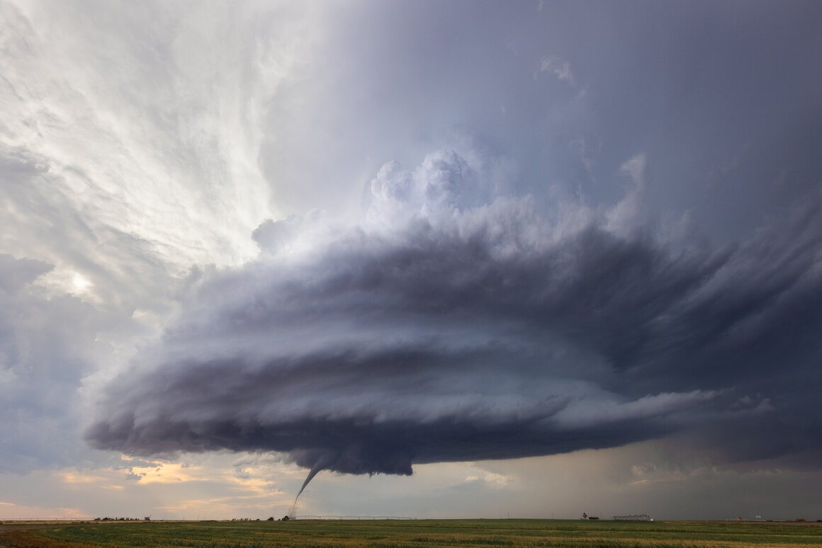 A small tornado drops under a supercell—a rare capture.