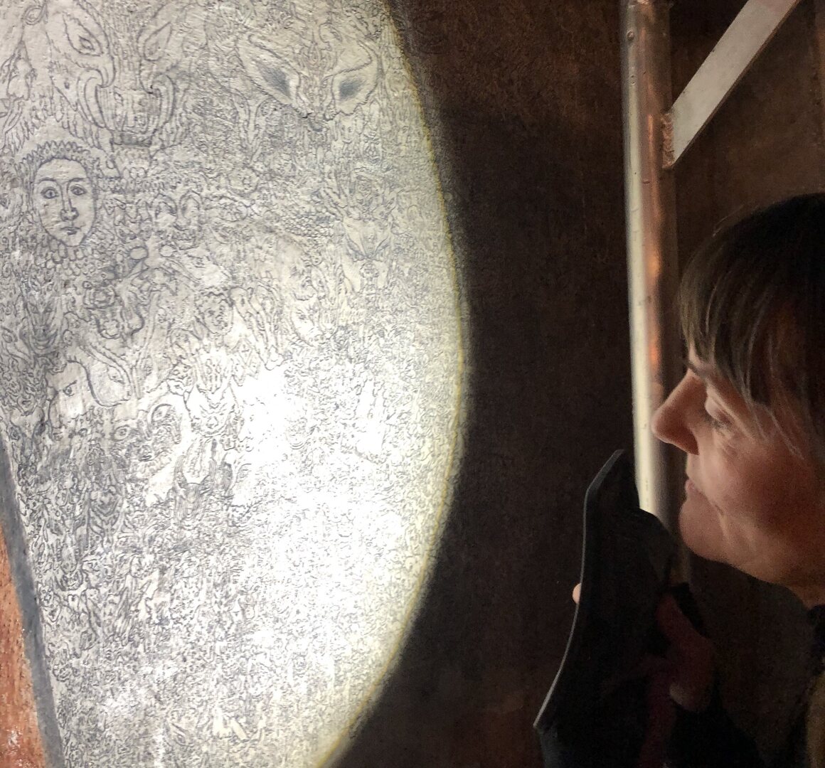 Standing on scaffolding, conservator Susanne Kaun studies a section of the demon wall. 