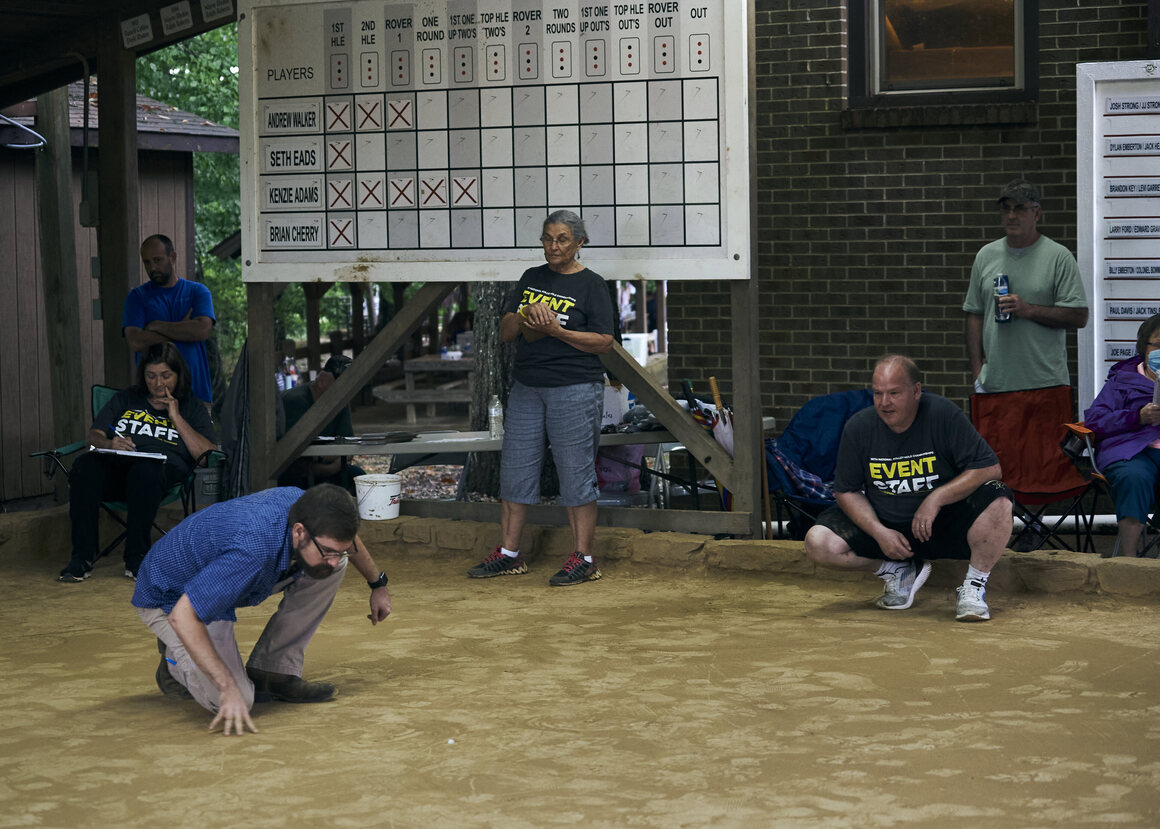 In rolley hole, two teams of two people compete to sink their marbles into three small holes in the middle of the marble yard 12 times in a prescribed order.
