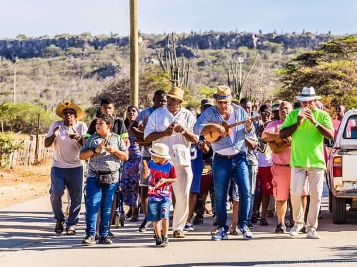 Meleno “Pachi Pe” Mercera (in green) and his son, Jeadan (in gray), lead musicians through the streets during the Simadan sorghum harvest festival.