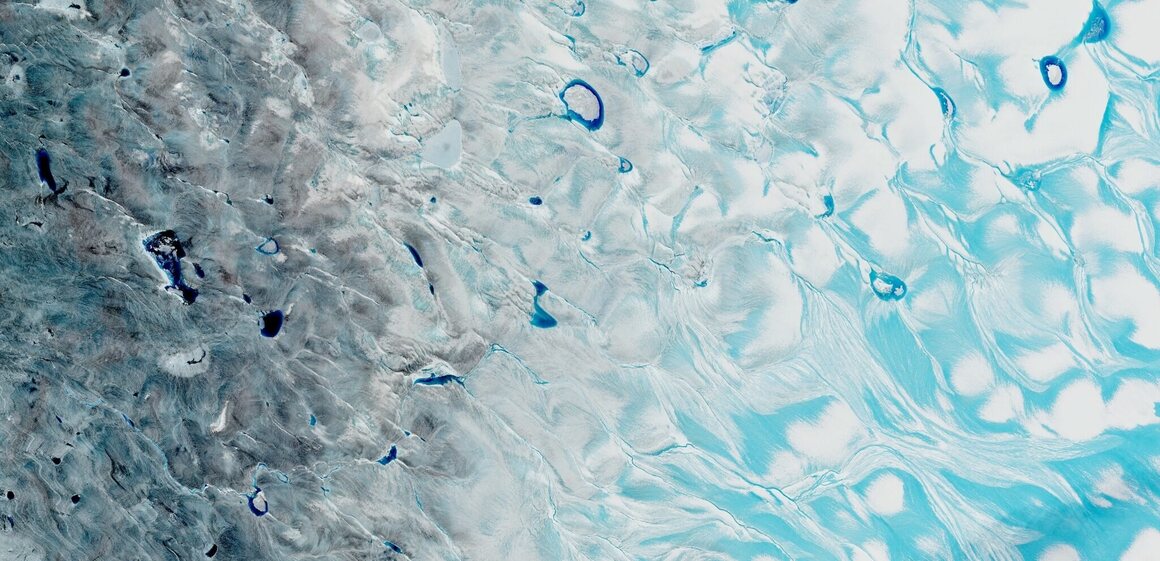 In a satellite image of the Greenland Ice Sheet's southwestern corner, captured on August 21, 2021, pale blue meltwater streams across ice or collects in slushy depressions. The deeper blue areas are meltwater lakes with depths up to about 30 feet. 