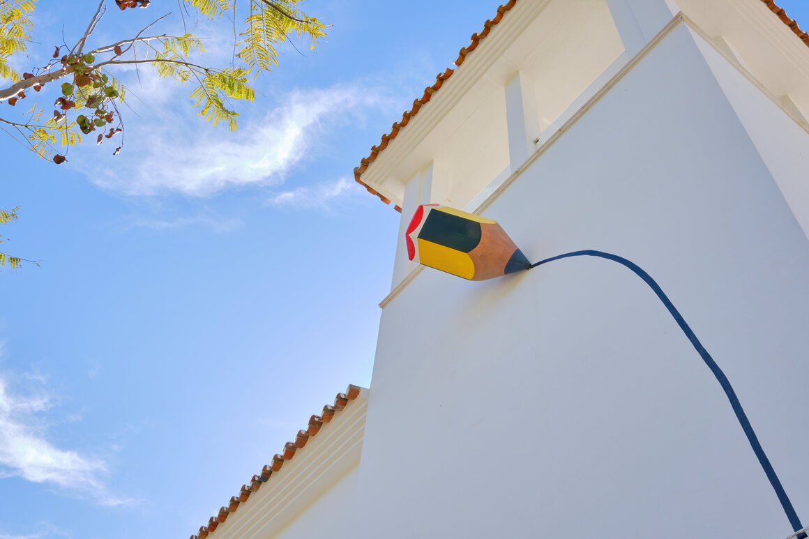 One of hundreds of art installations in the village, a whimsical pencil draws a line on a home in Genalguacil.