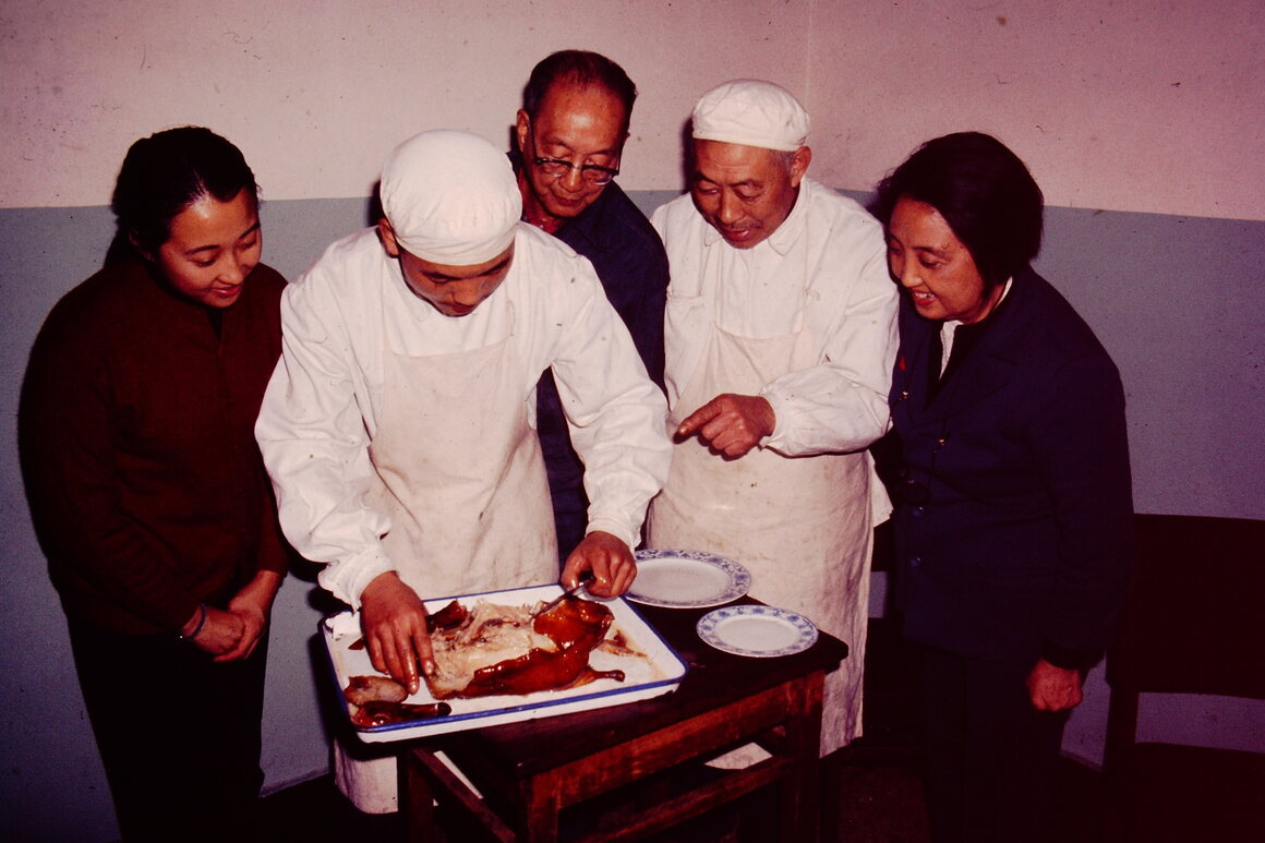 Helen (left) and Joyce Chen eagerly watch a chef slicing Peking duck.